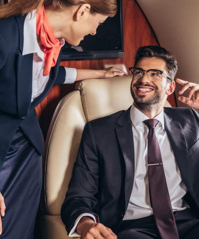 Flugbegleiterin und Fluggast sprechen im Privatjet