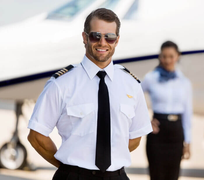 Flugkapitän und Flugbegleiterin stehen vor einem Privatjet